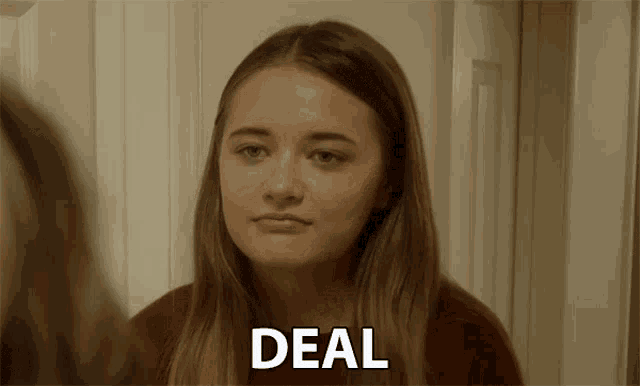 a girl is looking at herself in the mirror and the word deal is on the screen