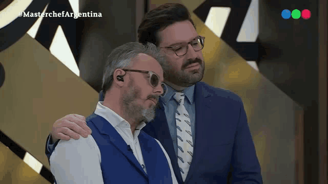two men are standing next to each other with the words masterchef argentina on the screen behind them