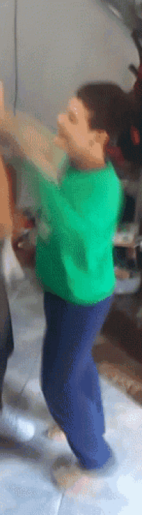 a young boy in a green sweater and blue pants is dancing