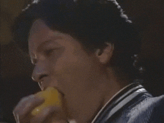 a close up of a man 's face with his eyes closed and a yellow object in his hand .