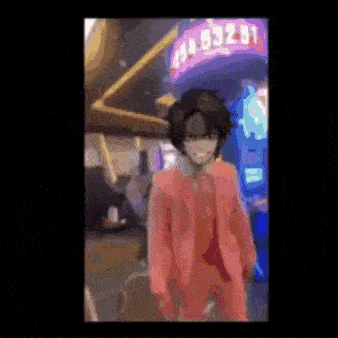 a man in a red suit is standing in front of a gambling machine .