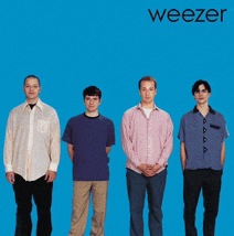 four men standing in front of a blue background with weezer written on the bottom