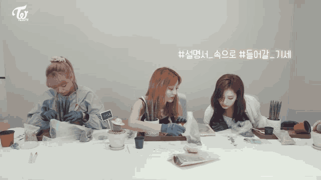 three women are sitting at a table with potted plants and a sign that says " twice " on it