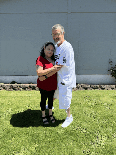 a man in a la dodgers shirt stands next to a woman