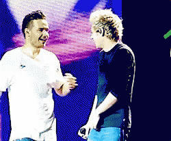 two men are standing next to each other on a stage talking