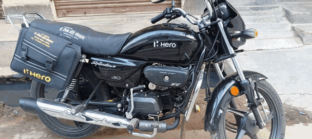a black hero splendor motorcycle is parked on the side of the road