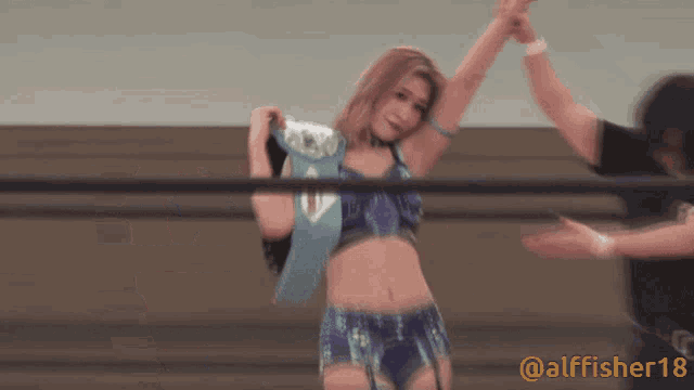 a woman in a wrestling ring is wearing a belt that says ' prime ' on it