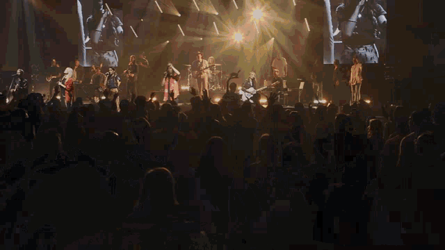 a man with long hair is playing drums in a dark room