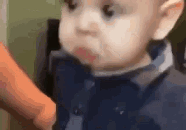 a baby is eating a carrot in a close up of his face .