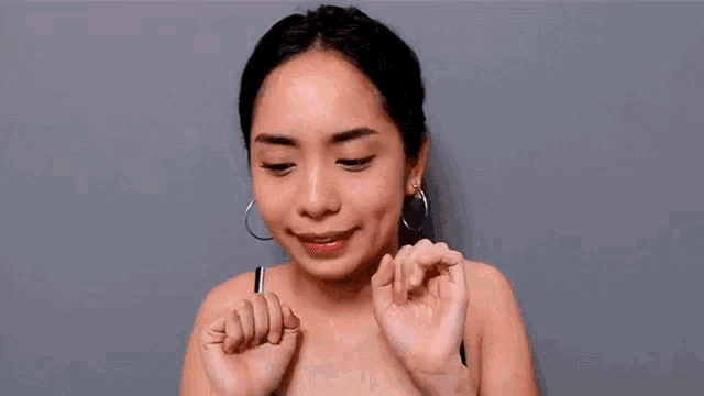 a woman wearing hoop earrings is making a funny face .