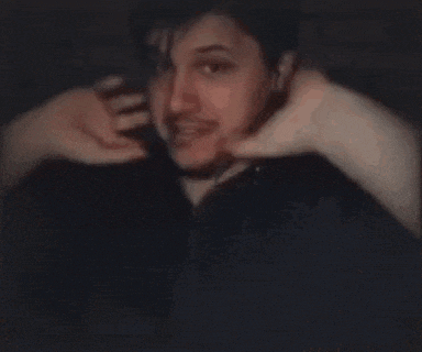 a man with a beard is making a funny face with his hands on his face .