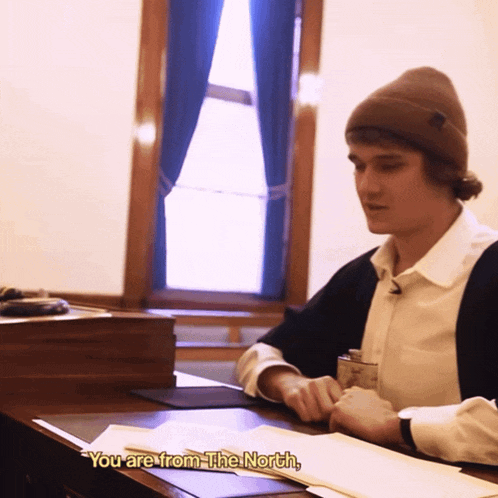 a man sits at a desk and says " you are from the north " in yellow letters