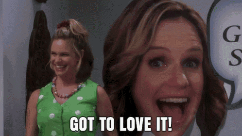 a woman is standing in front of a picture of a woman 's face and saying `` got to love it ! ''