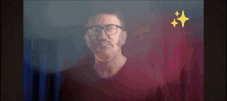 a man with glasses and a beard is standing in front of a red background