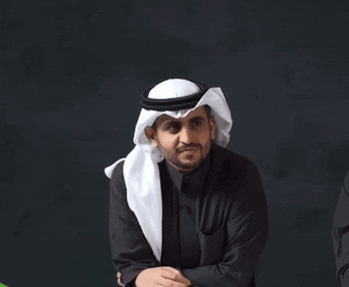 a man wearing a white head scarf and a black shirt