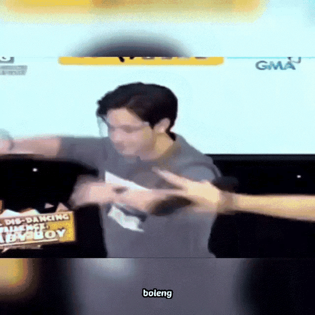 a man is dancing in front of a sign that says ' gma ' on it