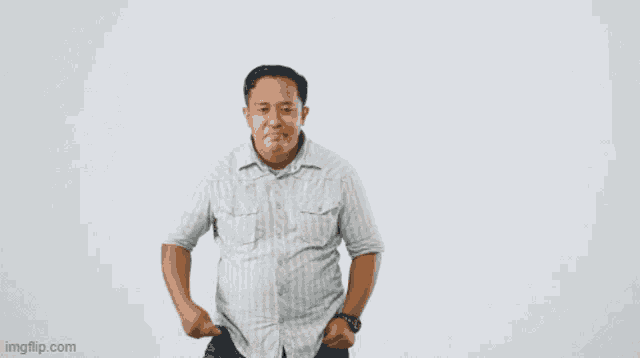 a man in a striped shirt is taking off his shirt against a white background