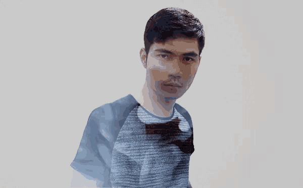 a man wearing a blue shirt with a batman logo on the front