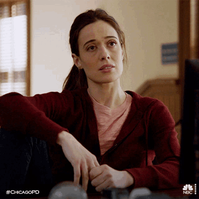 a woman sits at a desk with her hands folded and the hashtag #chicagopd on the bottom