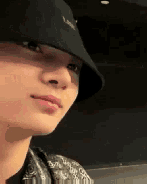 a close up of a person wearing a black hat and a bandana .