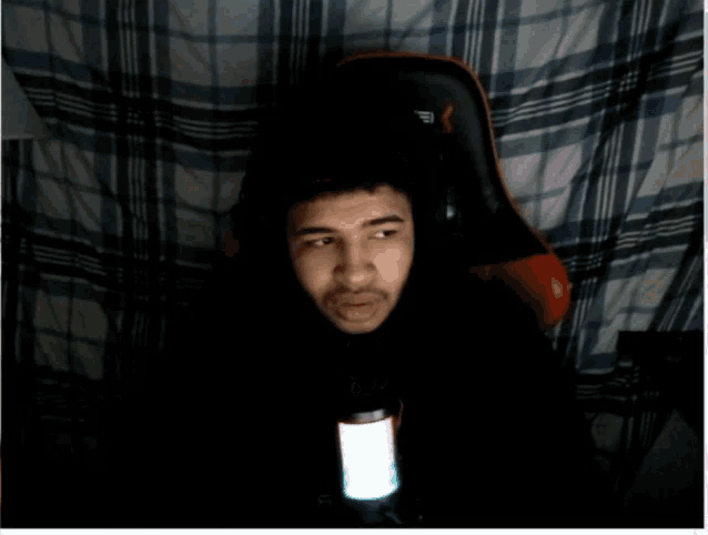a man sitting in a chair with a full screen and settings button