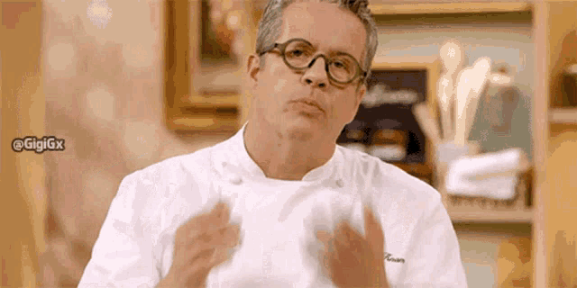 a man wearing glasses and a white chef 's jacket has the hashtag gigigx at the bottom