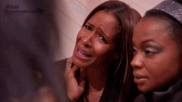 two women are sitting next to each other and one of them is crying and the words real housewives are on the bottom