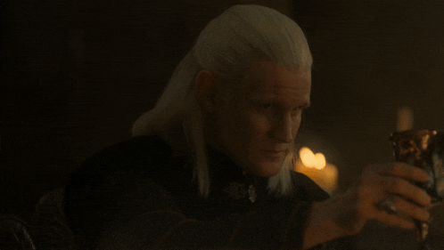 a man with white hair is holding a goblet in his hand