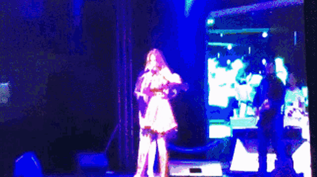 a woman singing on a stage with the words don maria live behind her