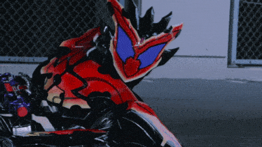 a person in a red and black costume with a blue eye