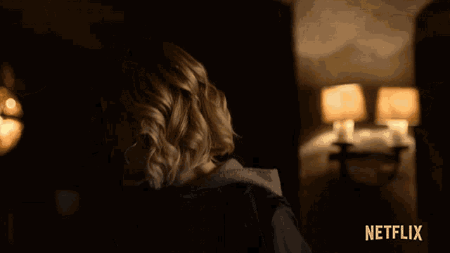 a woman in a dark room with a netflix logo on the bottom