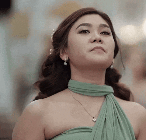 a woman wearing a green dress and a necklace