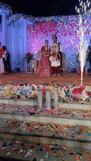 a bride and groom are standing on a stage surrounded by confetti