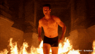 a shirtless man in black underwear is running through a room of fire