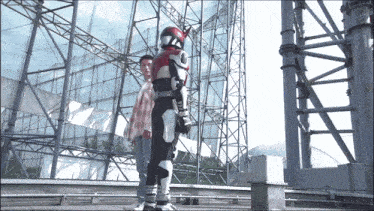 a man in a robot costume stands next to another man in jeans