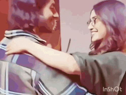 a man and a woman are hugging each other .