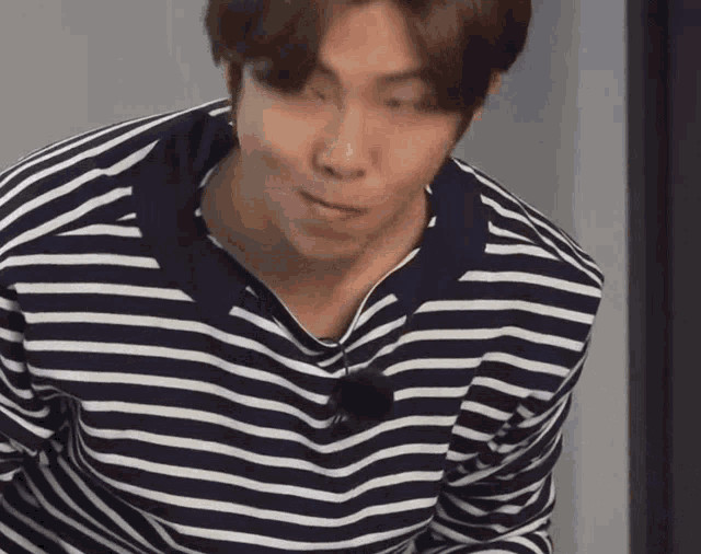 a man wearing a striped shirt is making a funny face