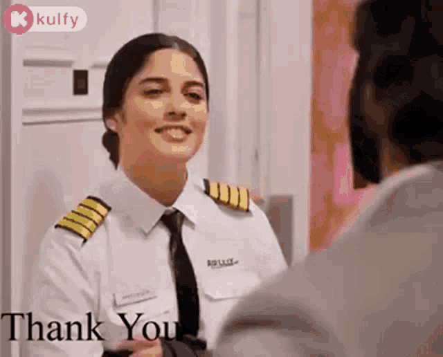 a woman in a pilot 's uniform is talking to a man .