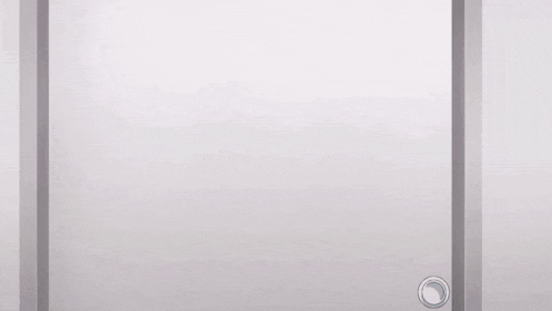 a girl is peeking out from behind a white door .