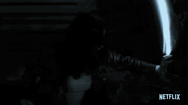 a netflix ad shows a person holding something in a dark room