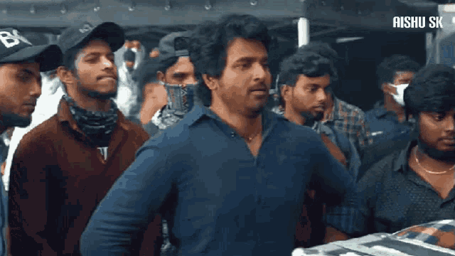 a group of men are standing in front of a sign that says aishu sk on it