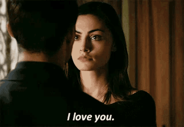 a man and a woman are looking at each other and the woman is saying i love you .