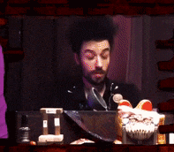 a man with a beard is sitting in front of a laptop computer