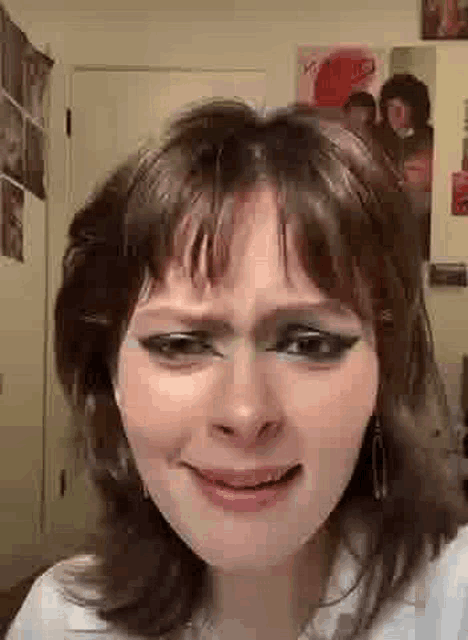 a close up of a woman making a funny face while wearing makeup .