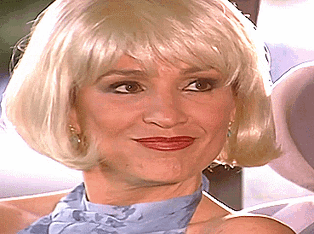 a close up of a woman 's face with blonde hair and red lipstick