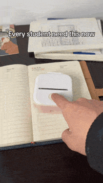 a person is pressing a button on a small device that says every student need this now