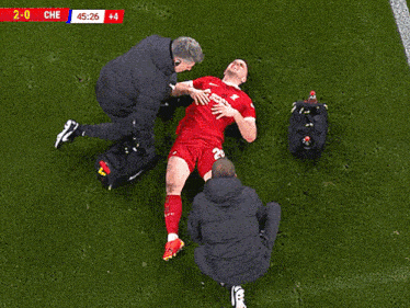 a soccer player is being helped on the field with the score 2-0 che