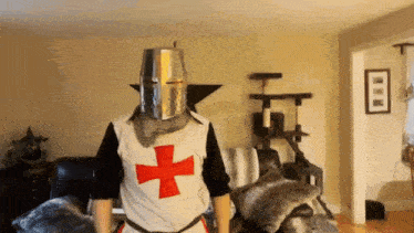 a man wearing a knight 's outfit with a red cross on it