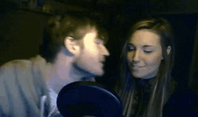 a man and a woman are kissing on a video call .