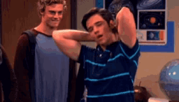 two young men are standing next to each other in a room .